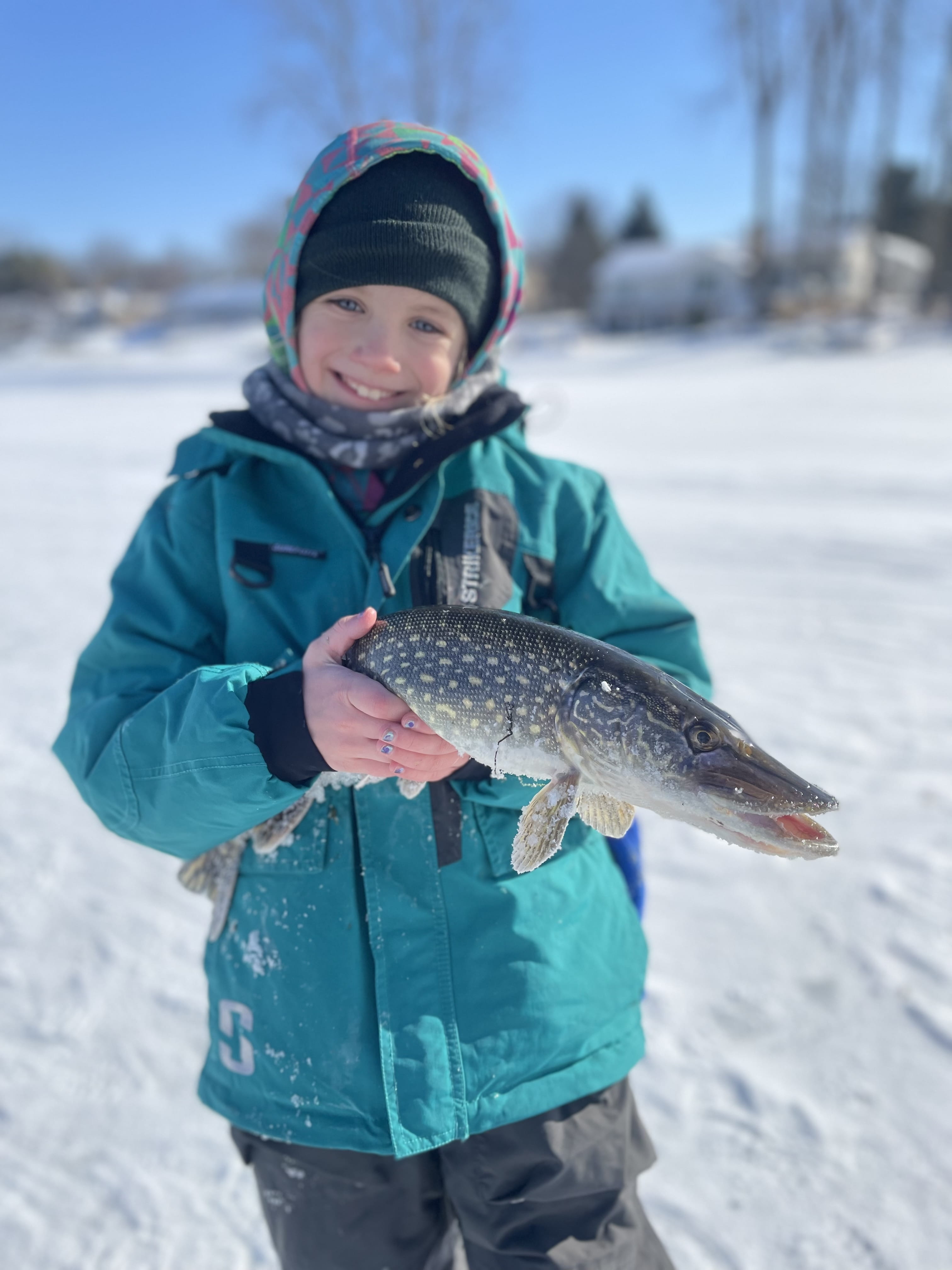 Brooke Armstrong, daughter of Brandon Armstrong, holds a pike she caught.