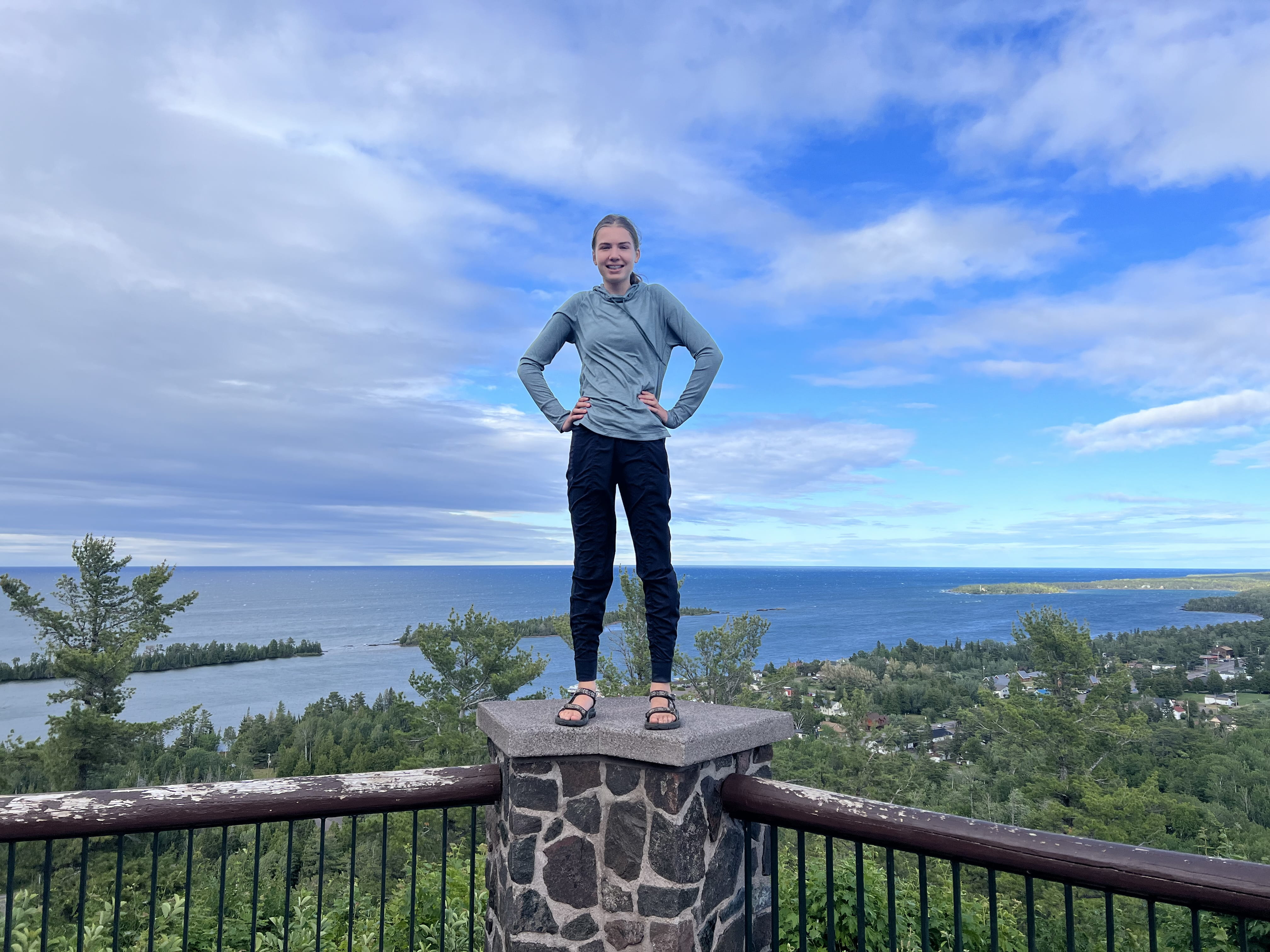 Ella Kecskemeti, 15 year old daughter of Tracy Kecskemeti, assistant director of Materials Management Division, standing on stone corner of balcony railing overlooking water.