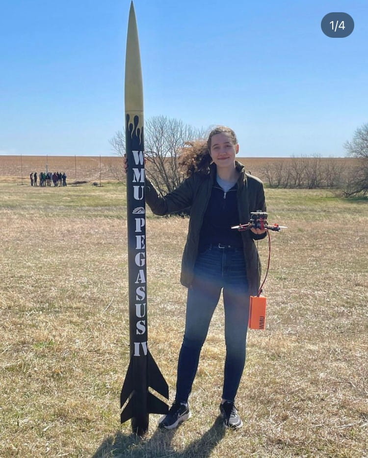 Grace Klang, daughter of Jennifer Klang, standing next to Western Michigan University Pegasus IV rocket.