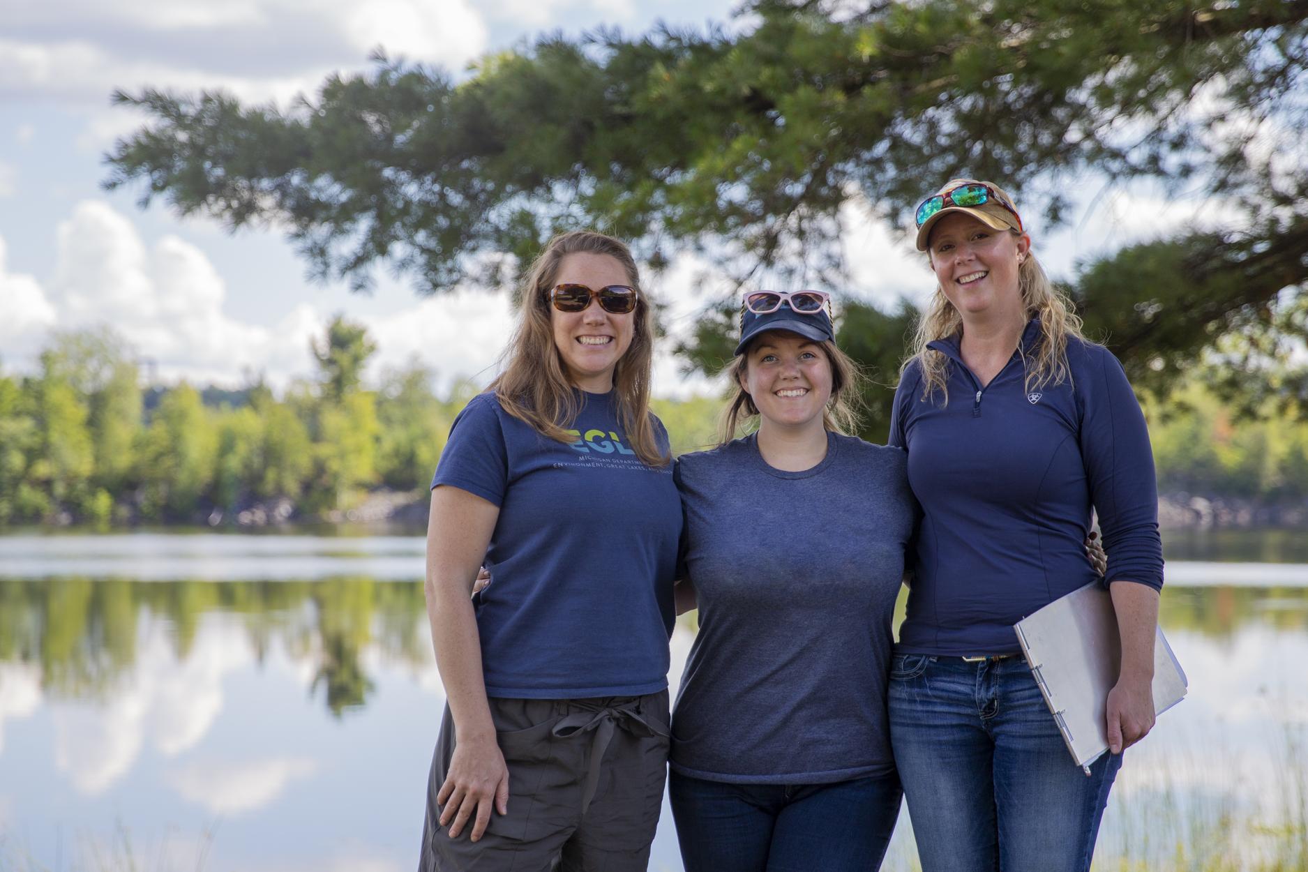 Three Water Resources Staff Posing for a photo outside with a lake in the background
