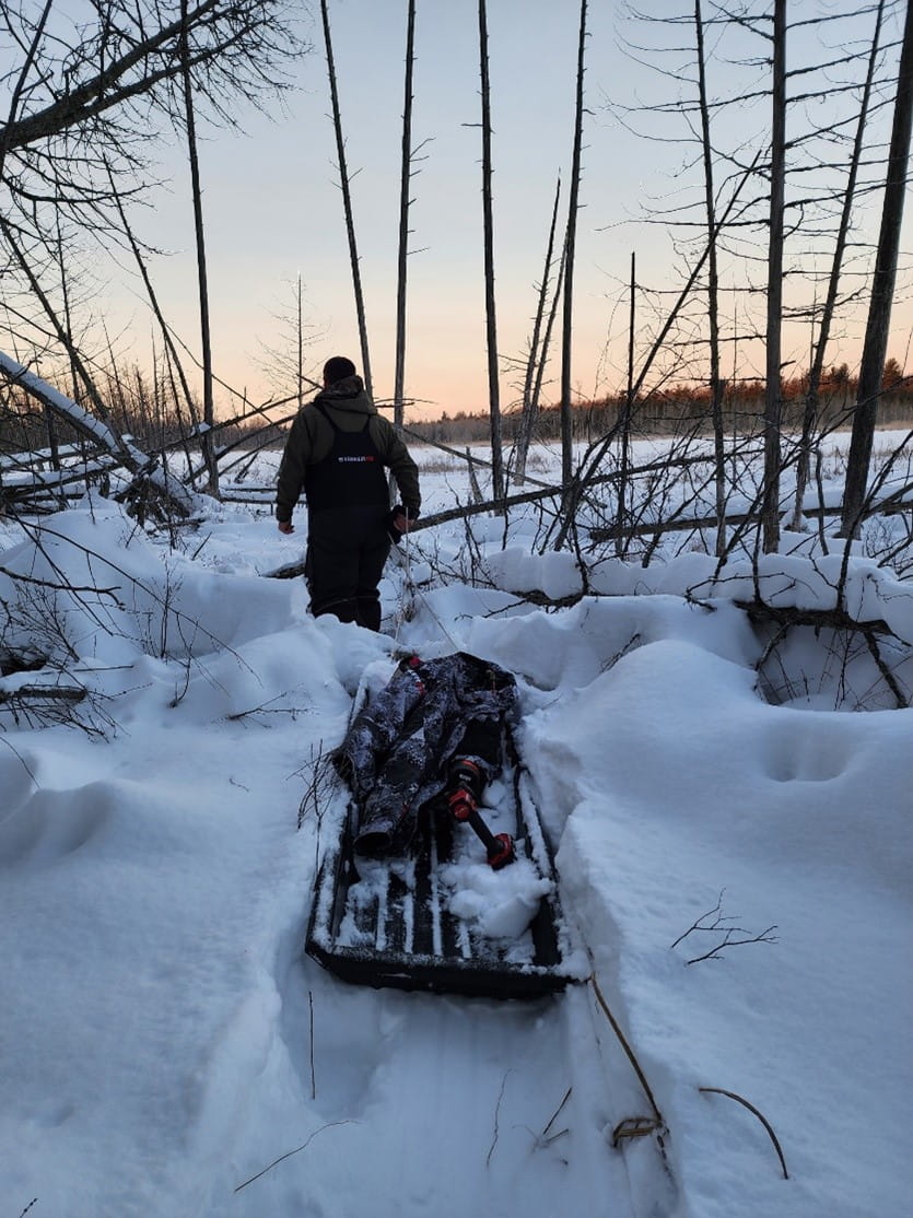 EGLE staff pulling a sled and traversing a wetland complex to reach Clarks Marsh.