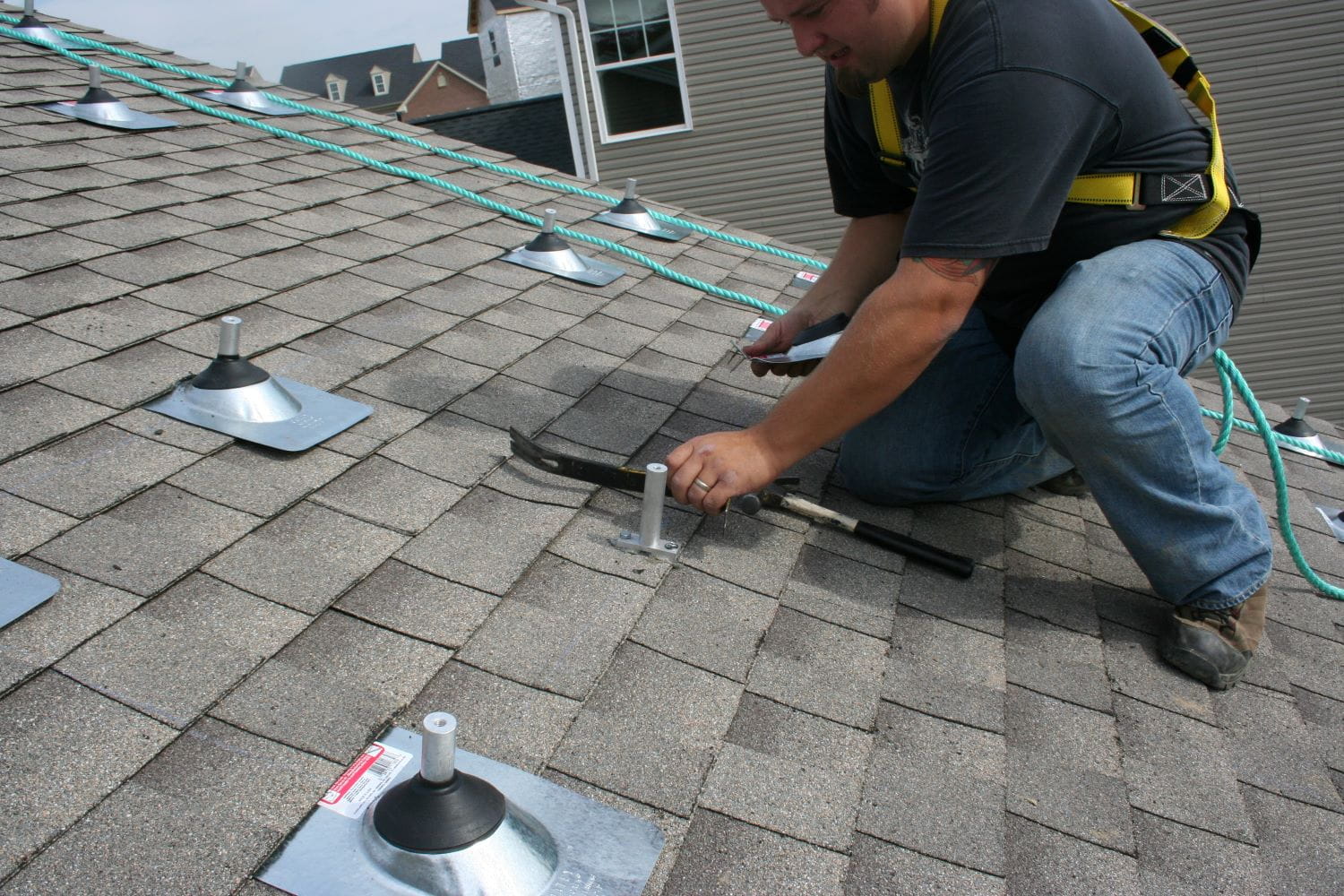 A worker installing a roof mounting photovoltaic (PV) system for solar panels
