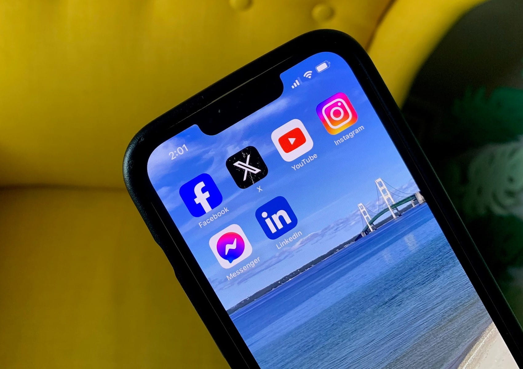 A smartphone showing the apps Facebook, Messenger, LinkedIn, YouTube, Instagram, and X (Twitter)