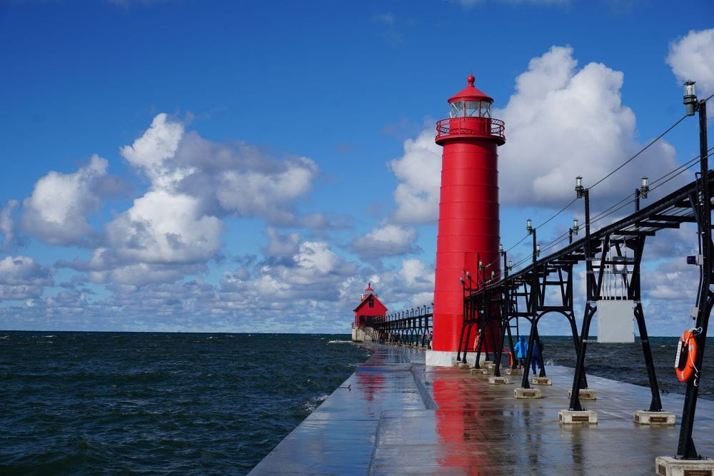 The bright red Grand Haven lighthouse at the end of the pier sticking into Lake Michigan