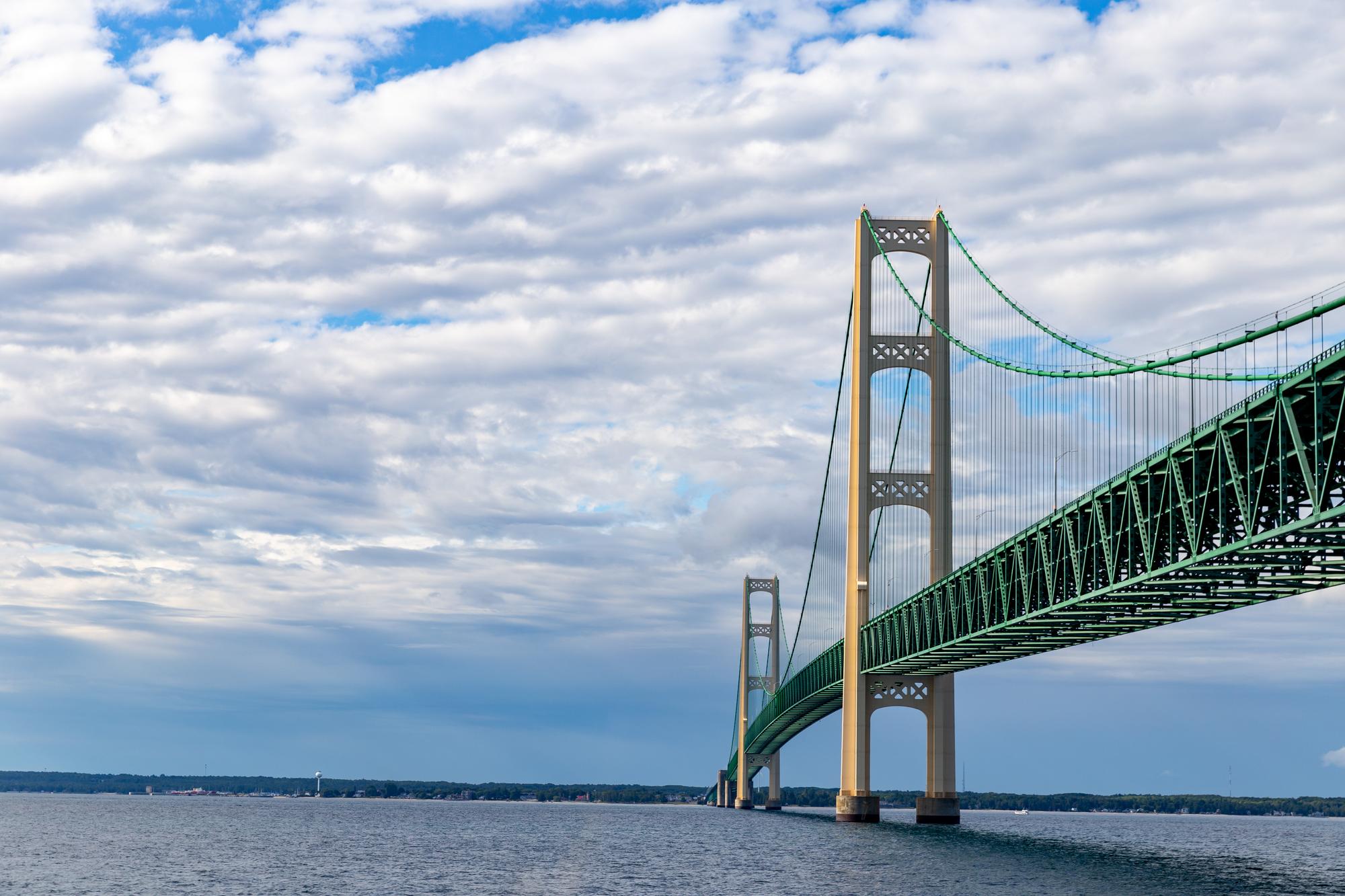 The Mackinac Bridge stretching over the Straits of Mackinac, a cloudy sky above