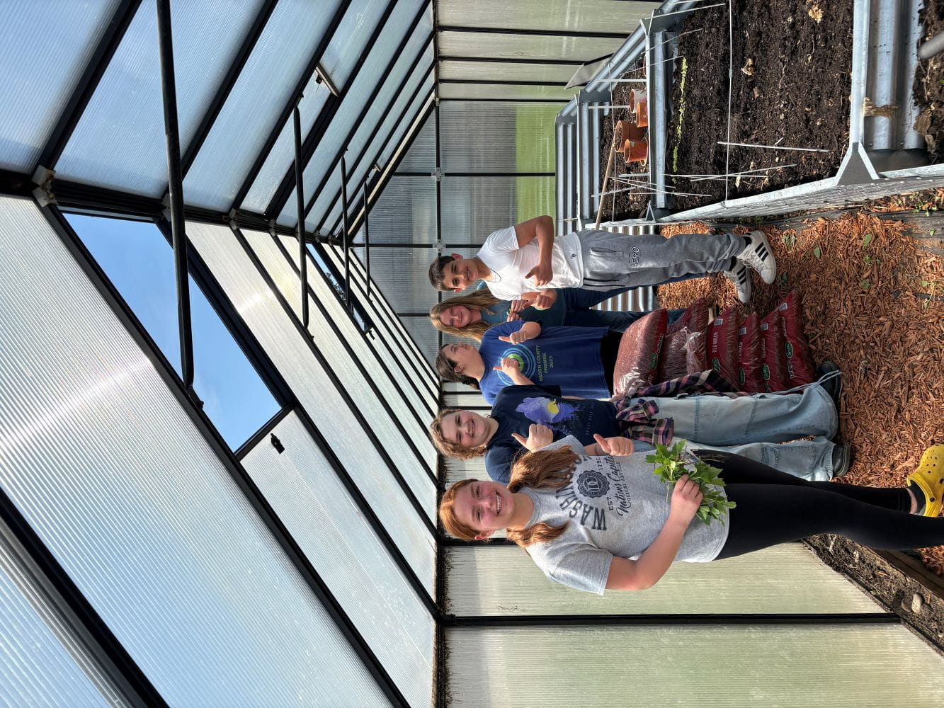 Mason County Eastern Schools’ science class students proudly show off produce they’ve grown in their newly revitalized greenhouse.