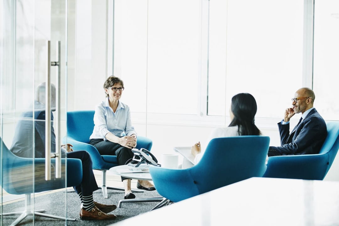 Four people sitting around a table are discussing something