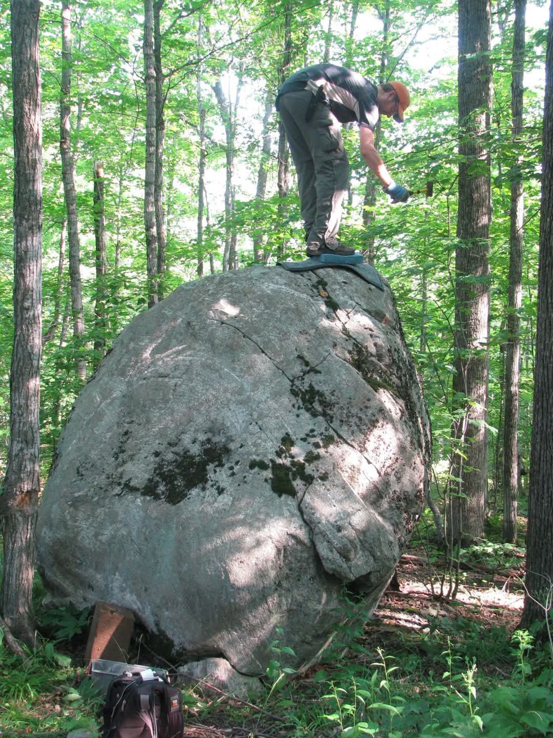 EGLE geologist Kent Walters atop a glacial erratic rock in the Upper Peninsula.