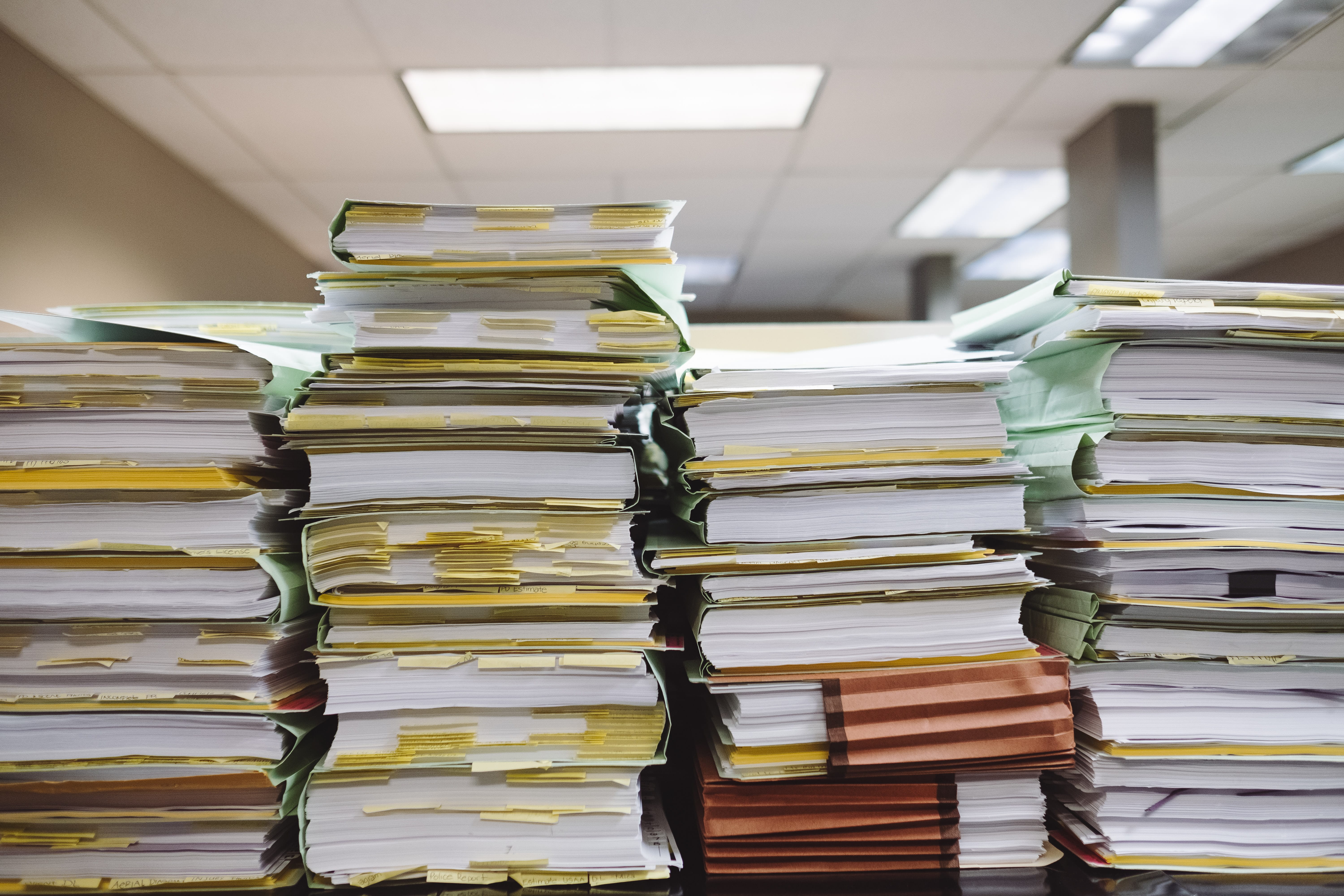 Stacks of files and documents with sticky notes throughout