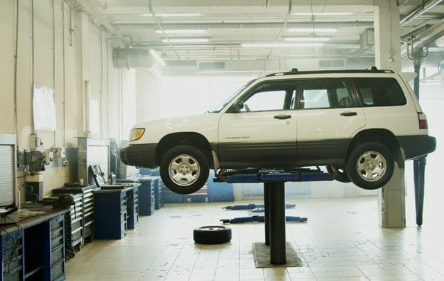 white car on lift in auto repair shop