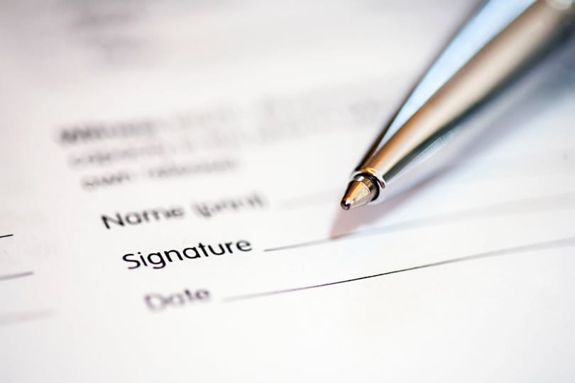 Close up of a pen about to sign a form
