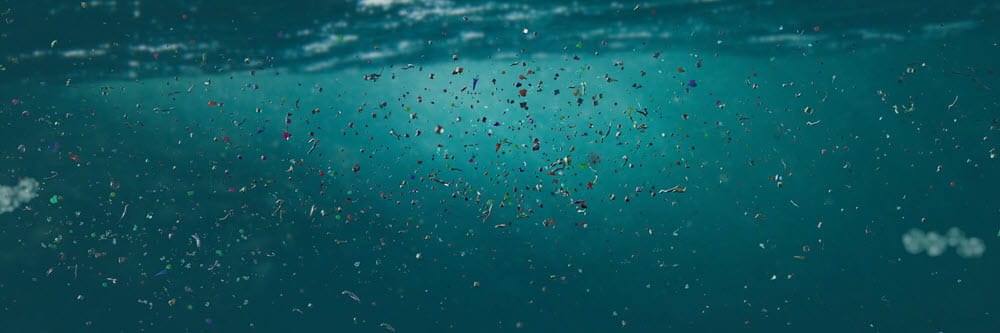 microplastics floating in dark, greenish blue water