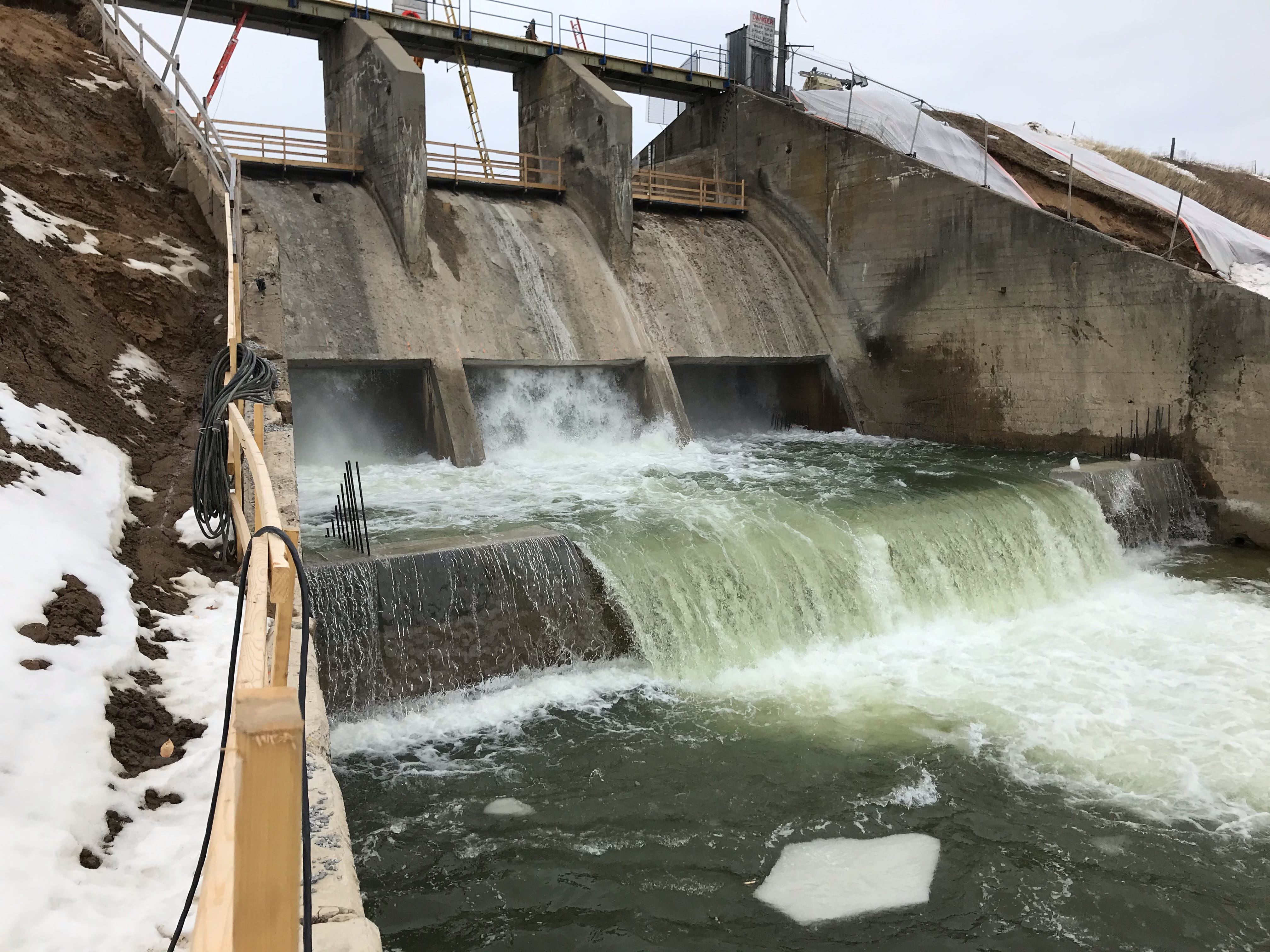 The Edenville Dam Spillway with water flowing over it.