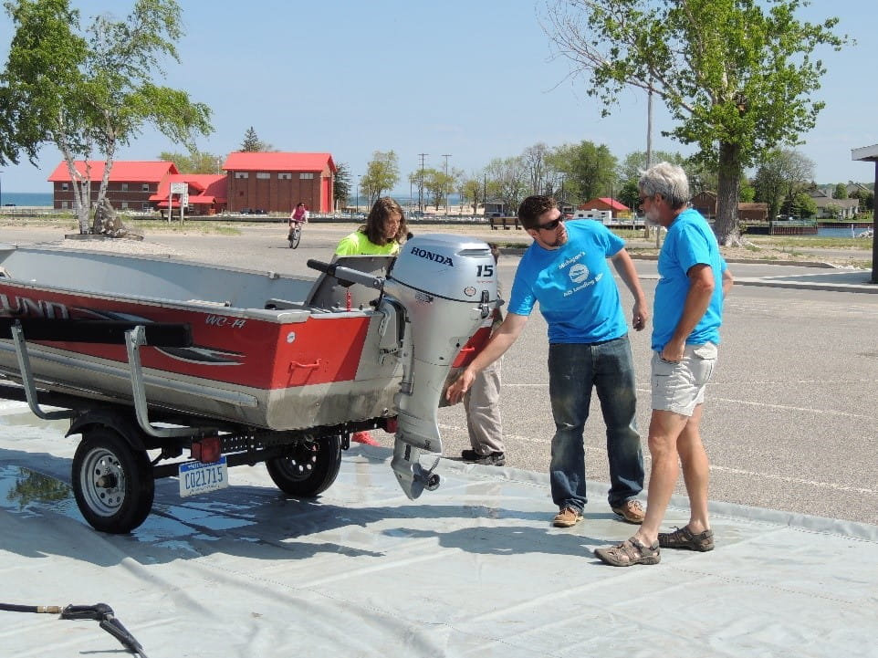 An MSU student & Mobile Boat Wash crew member educate on Clean, Drain and Dry in Manistee