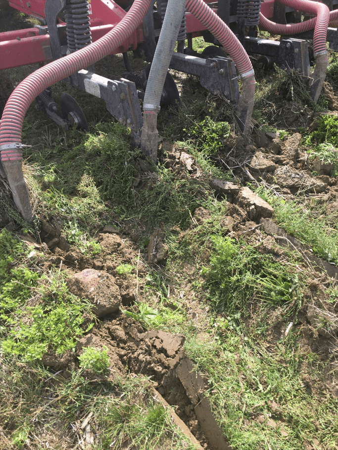 A picture of biosolids being injected below the surface on a farm field  