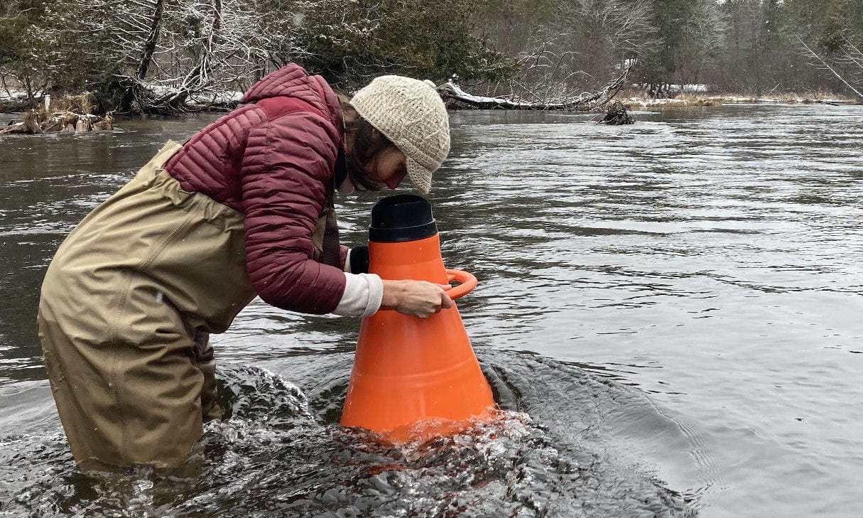 Sarah LeSage using a bathyscope (aka aquascope or underwater viewer) to examine the stream bed