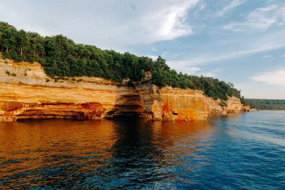 A reddish-orange rocky cliff, part of Pictured Rock National Lakeshore overlooking Lake Superior
