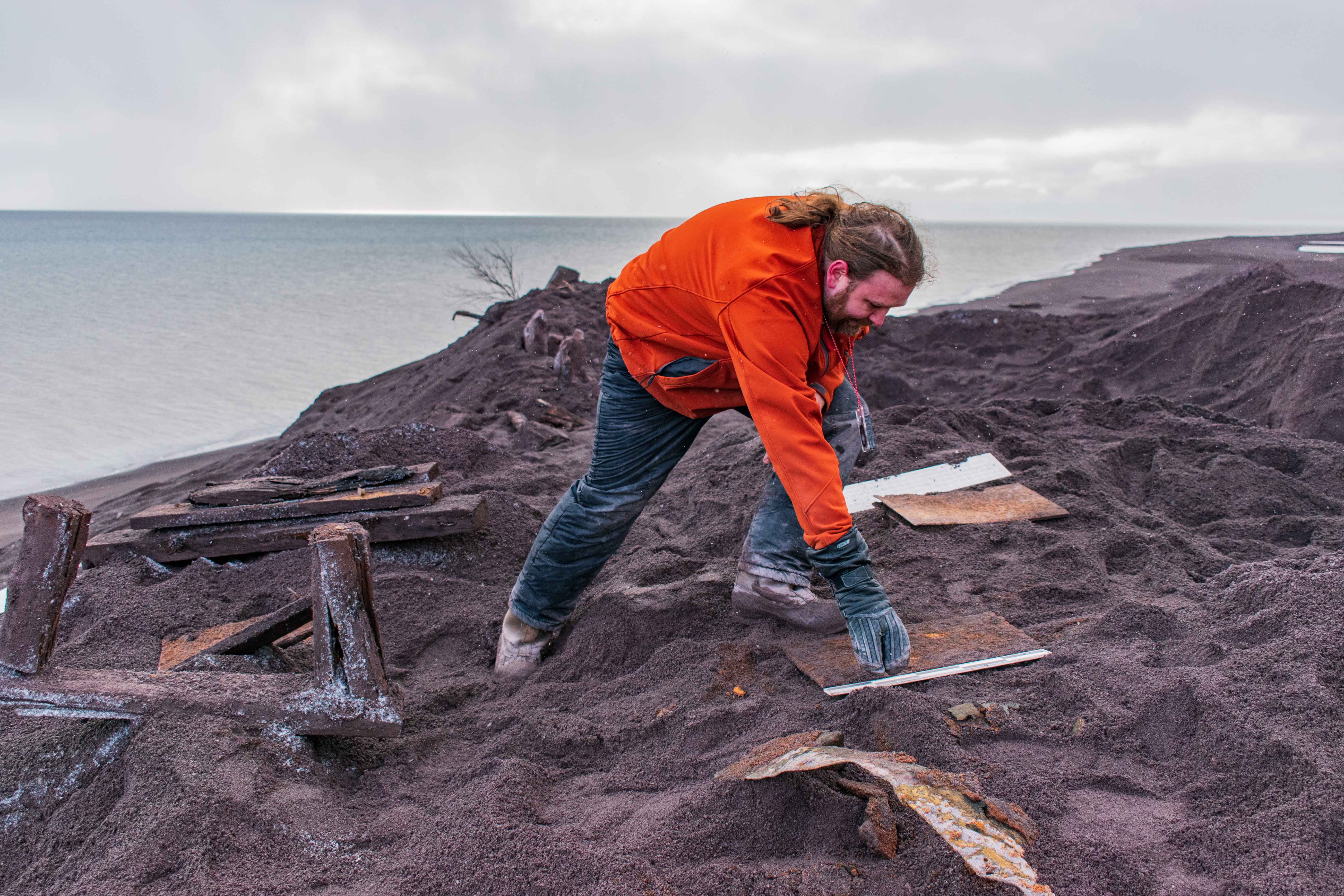 An archaeologist uncovers stamp mill workings along the Lake Superior shore outside Gay, Michigan. (Neal Harri photo)