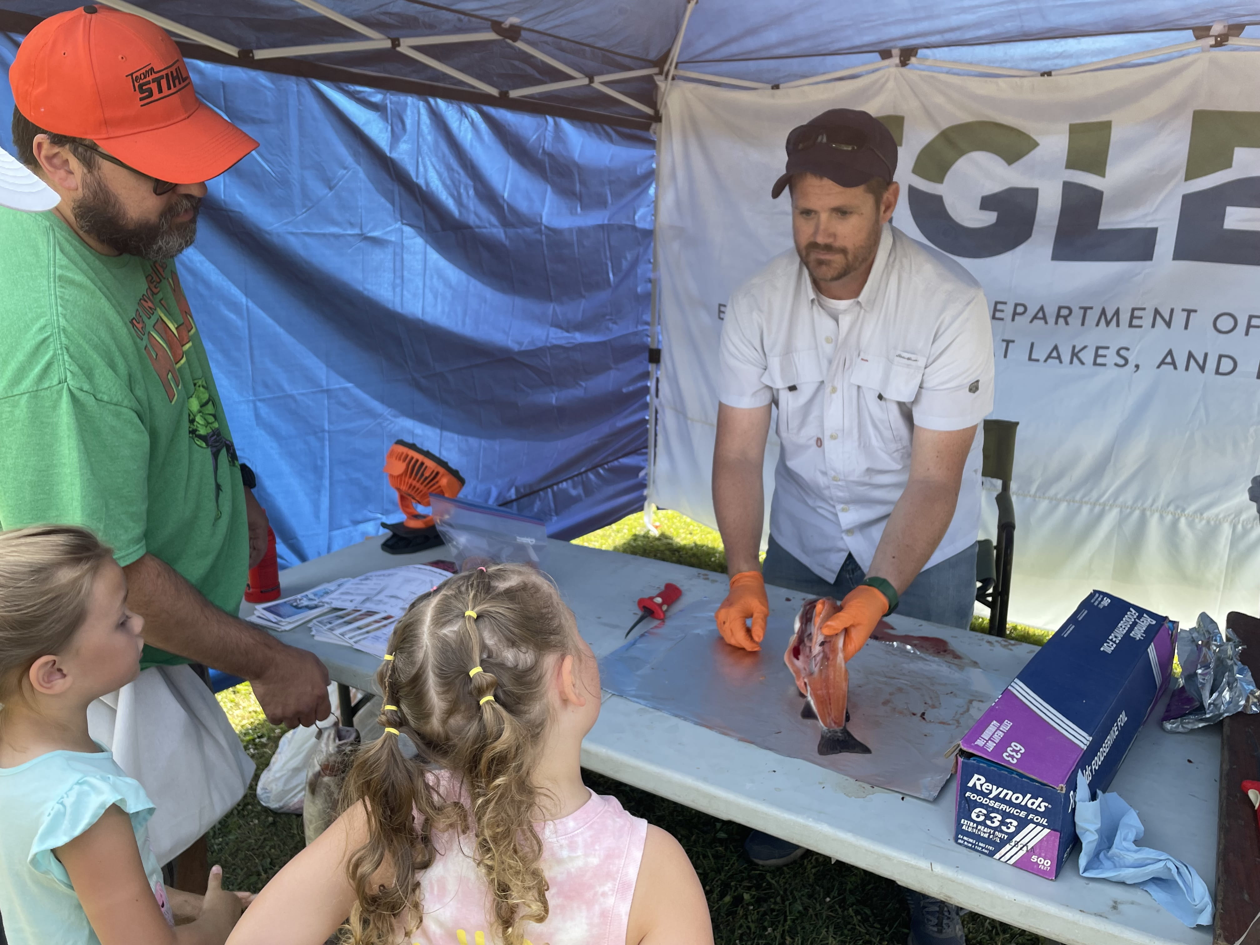 Brandon Armstrong helps fillet a largemouth bass for contaminant monitoring at the Wayne County Parks youth fishing derby at Waterford Bend Recreation Area in Northville.