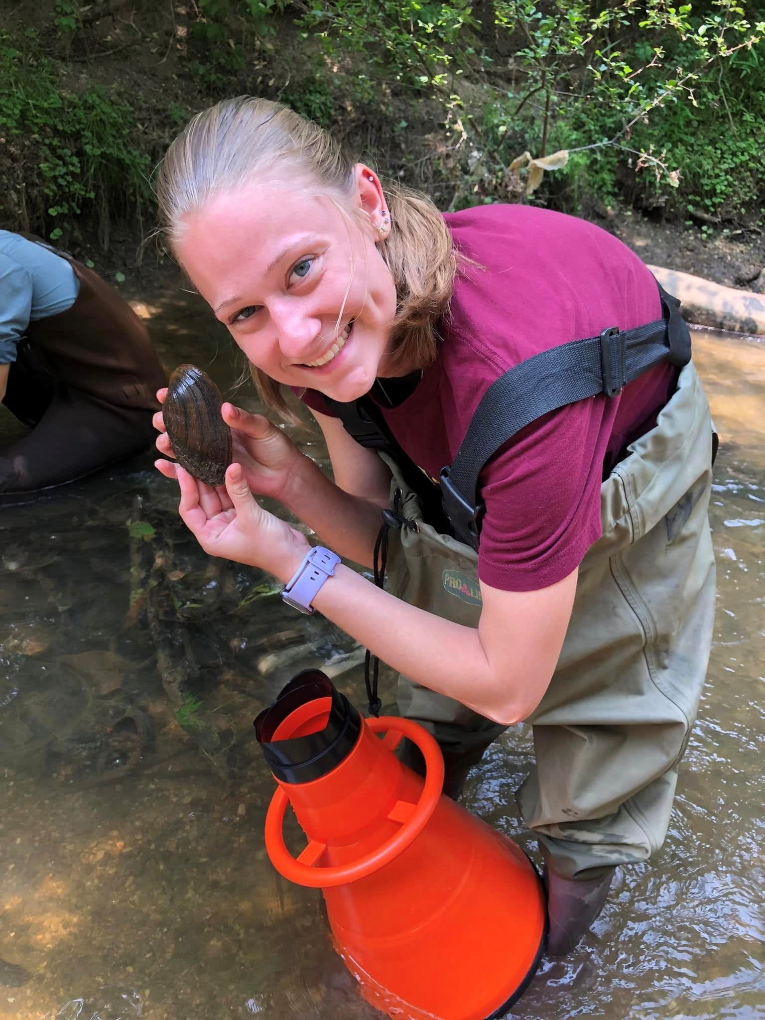 Julia Klooster, a Calvin University student, finds the first mussel during the first mussel survey on the Plaster Creek.