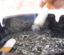 hand stubbing out a cigarette in an ashtray