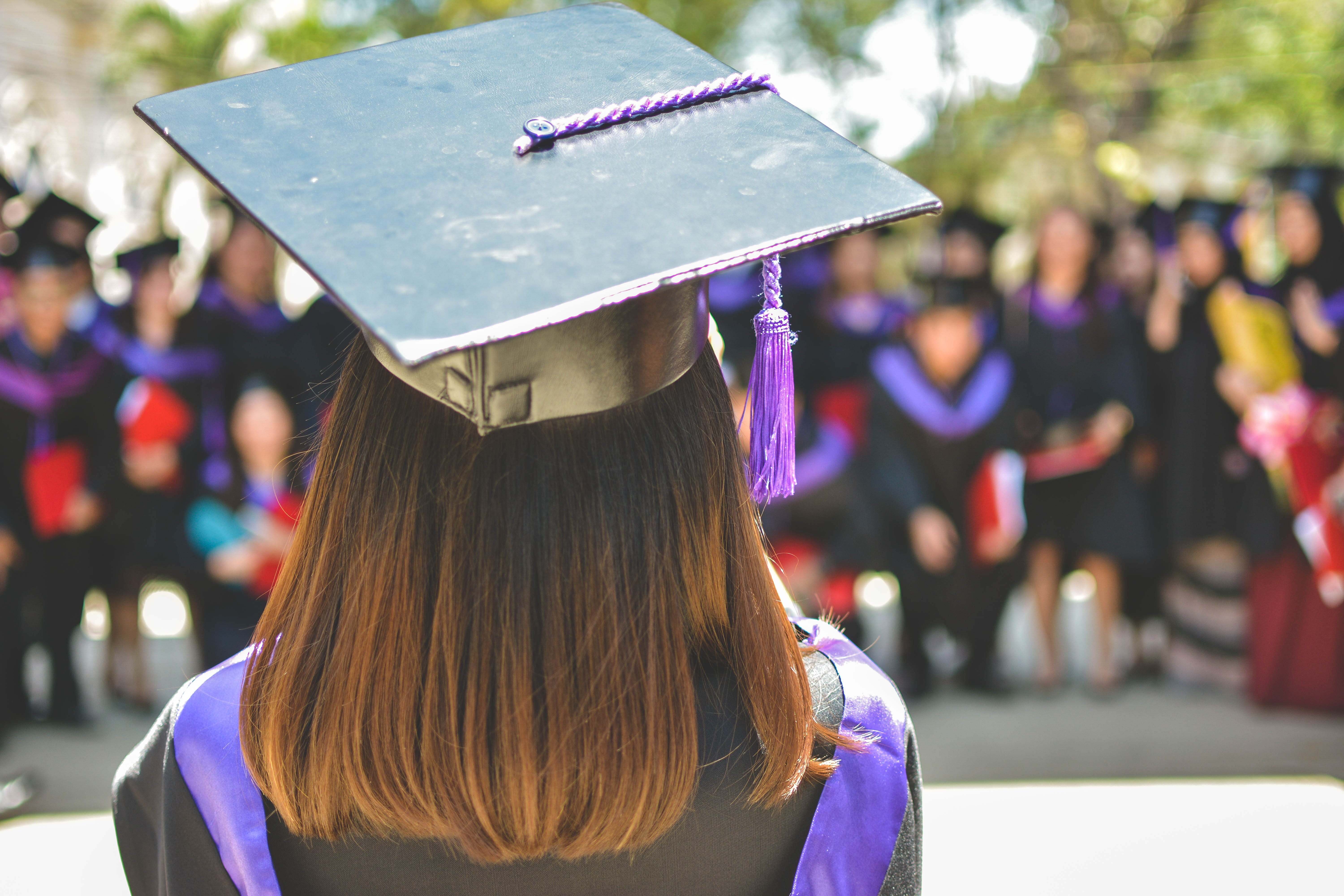 Woman wearing graduation cap and gown.