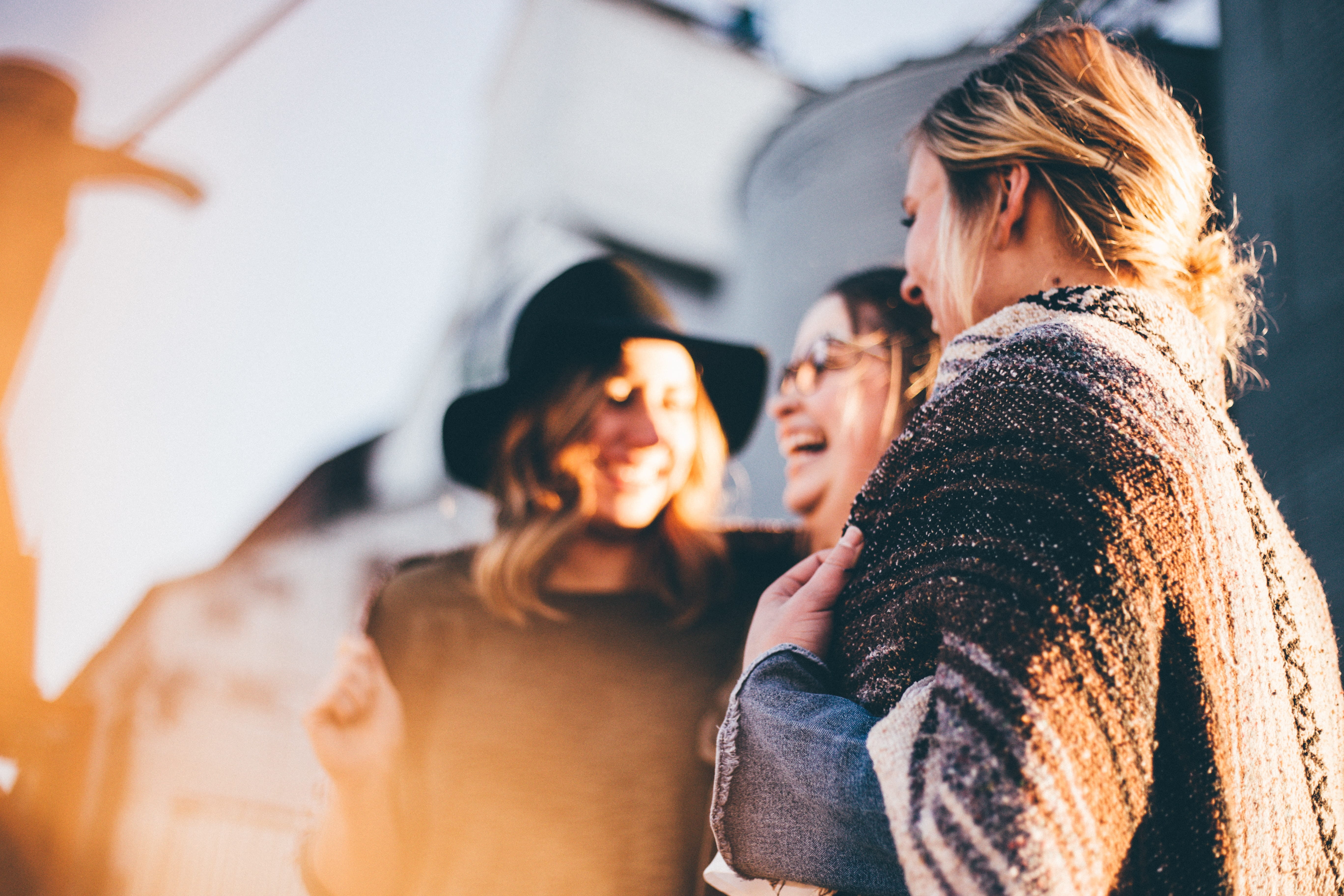 Photo of three women talking outside.