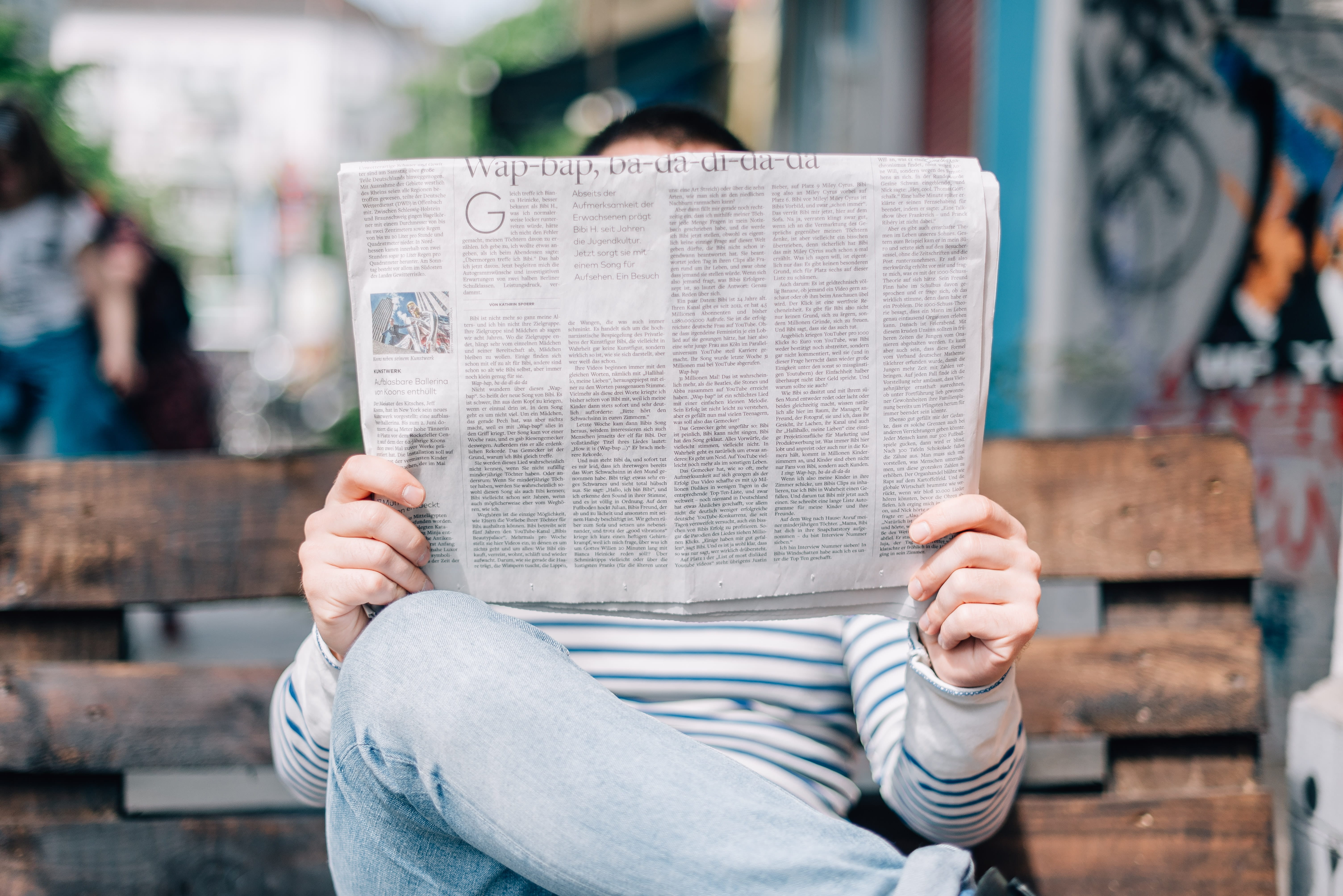Photo of a person reading the newspaper.