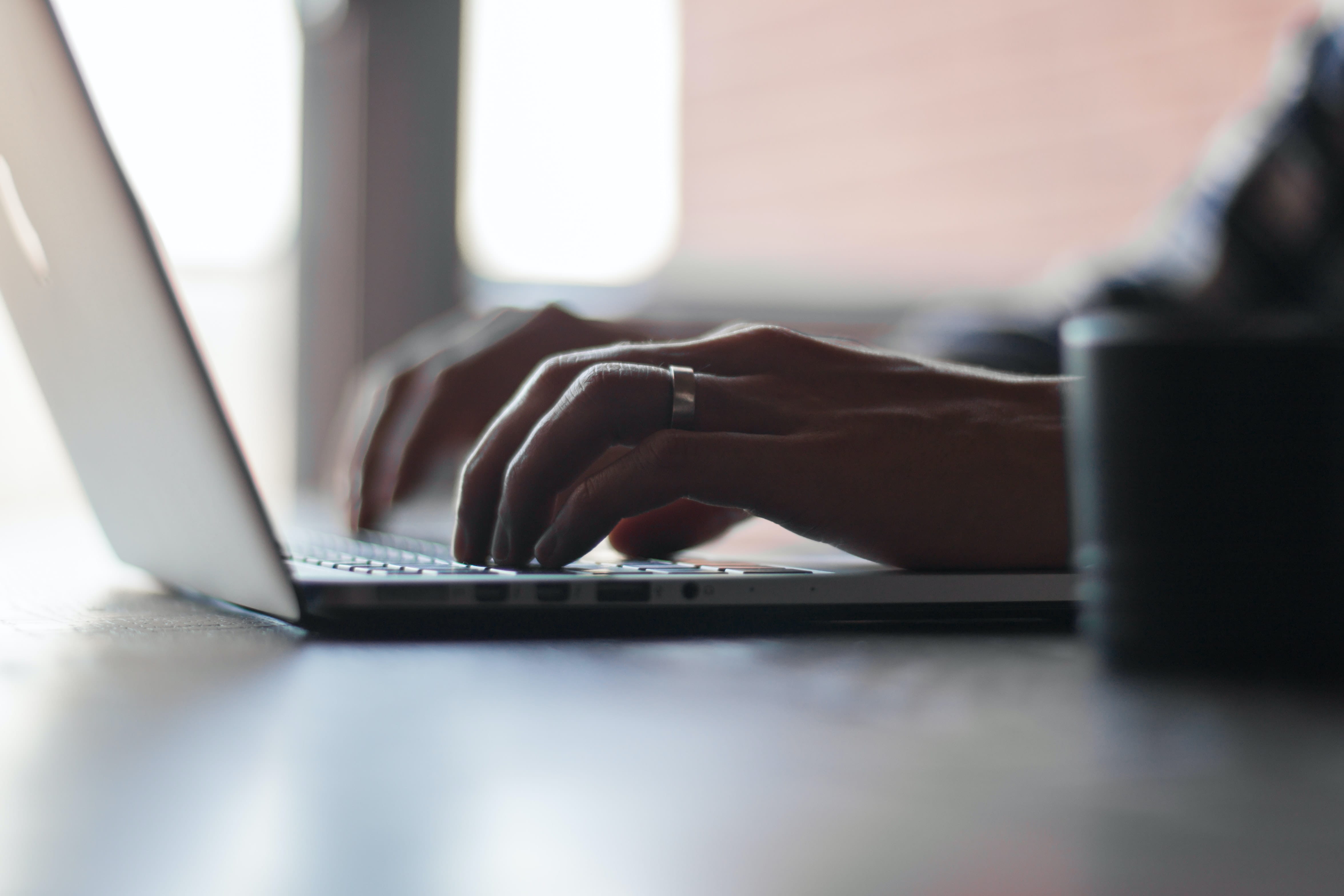 Photo of a person typing on a laptop.