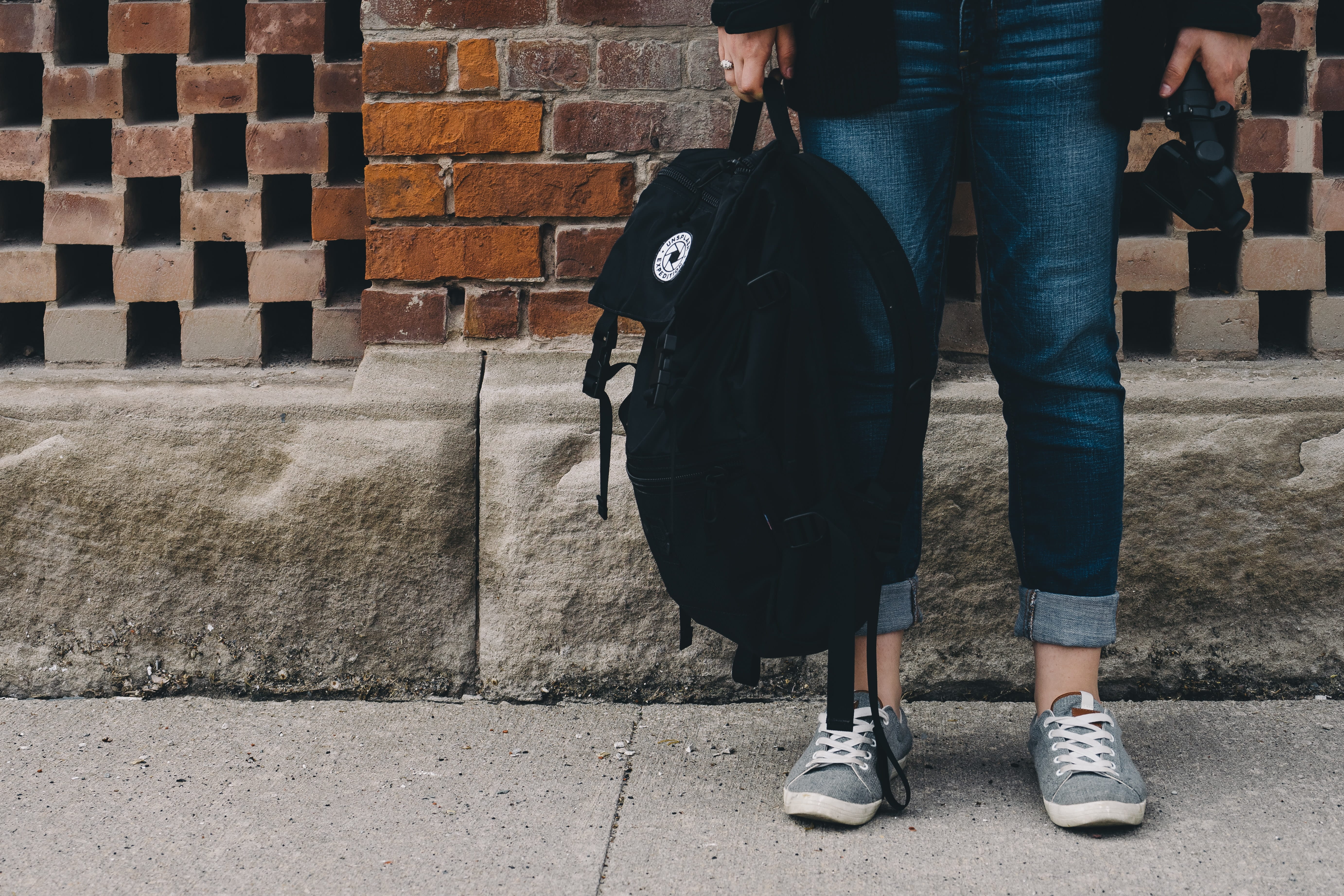 Photo of a person holding a bookbag.