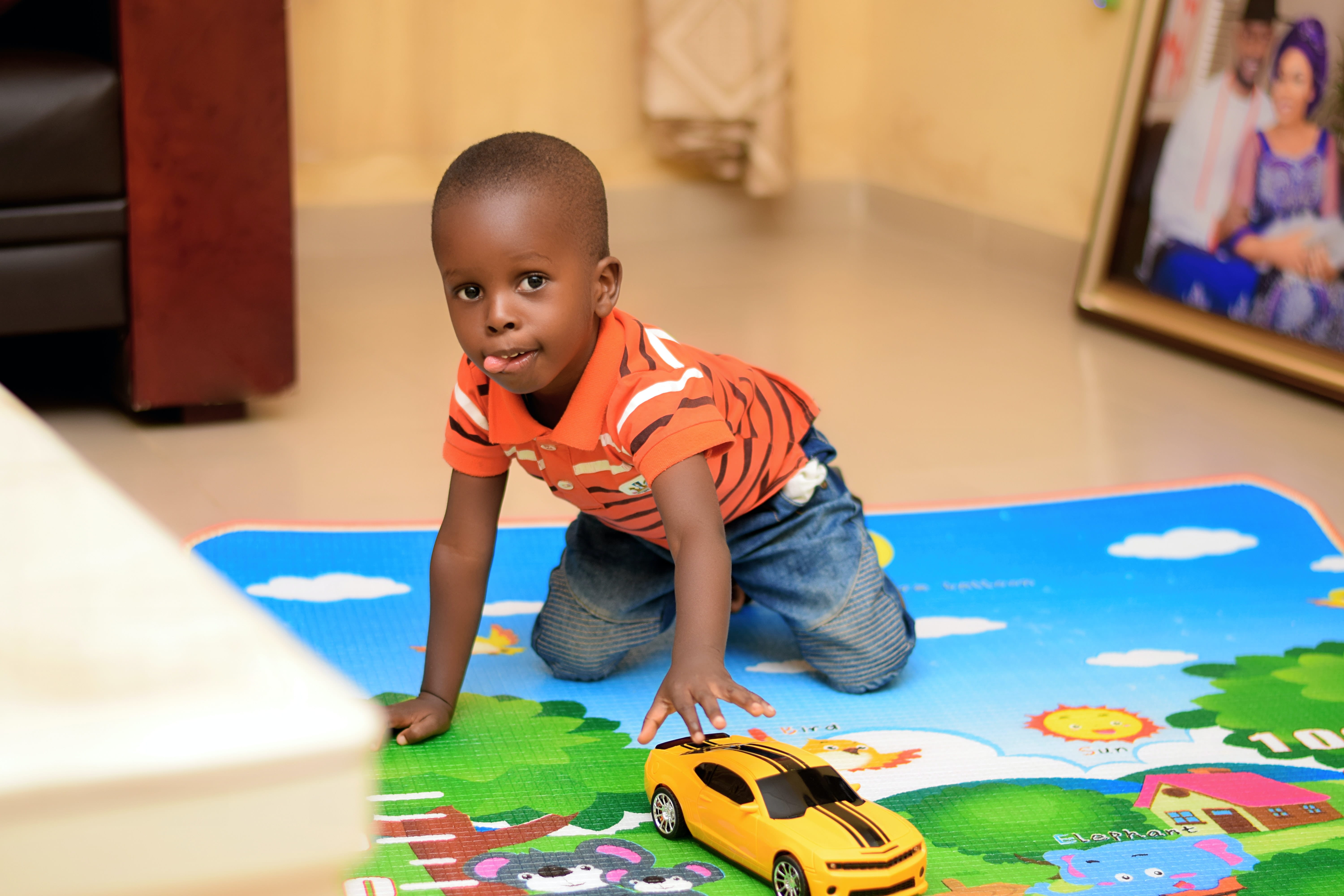 Photo of a toddler playing with a toy car.