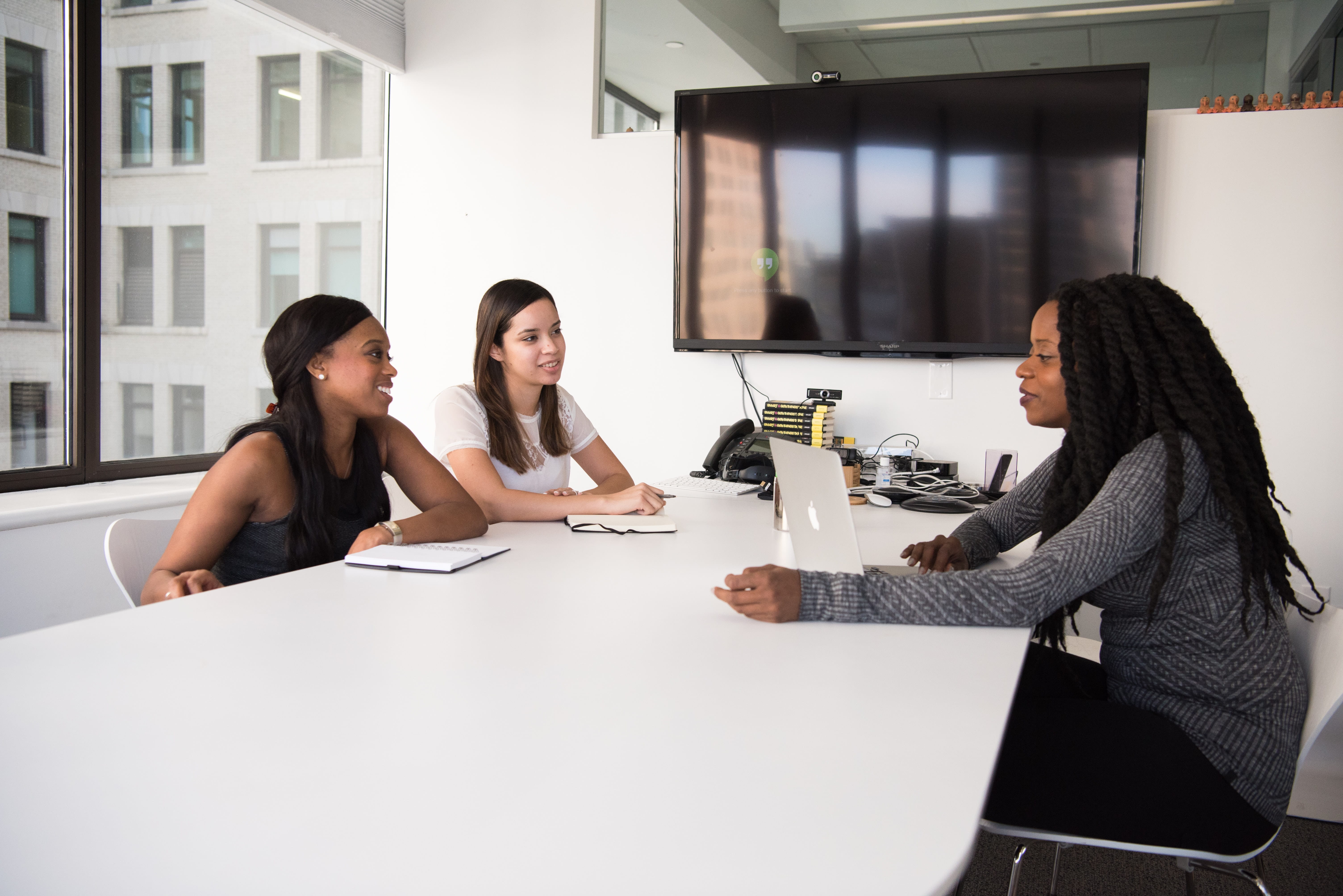 Photo of three women having a meeting in a conference room.