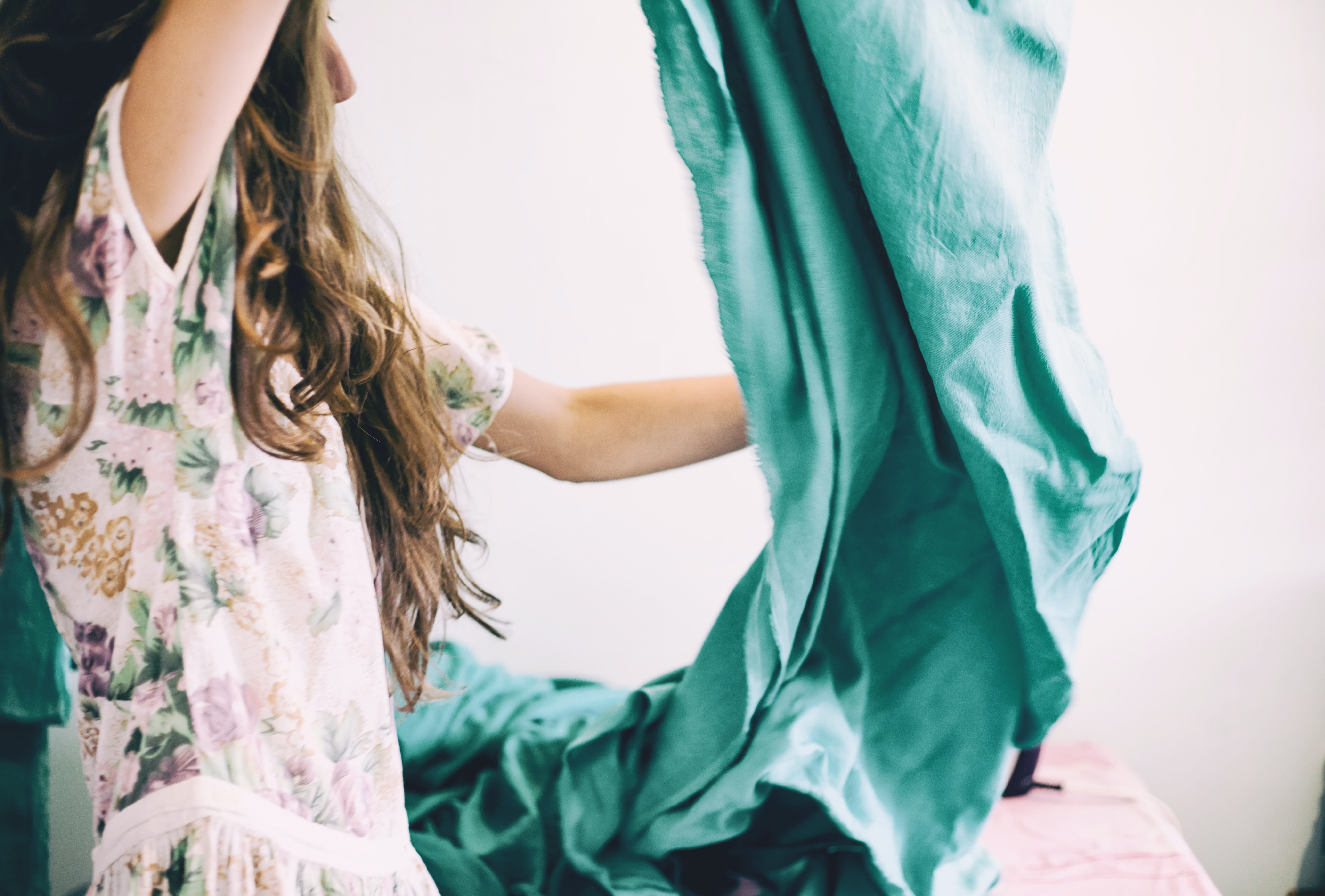 Photo of a person folding a bedsheet.