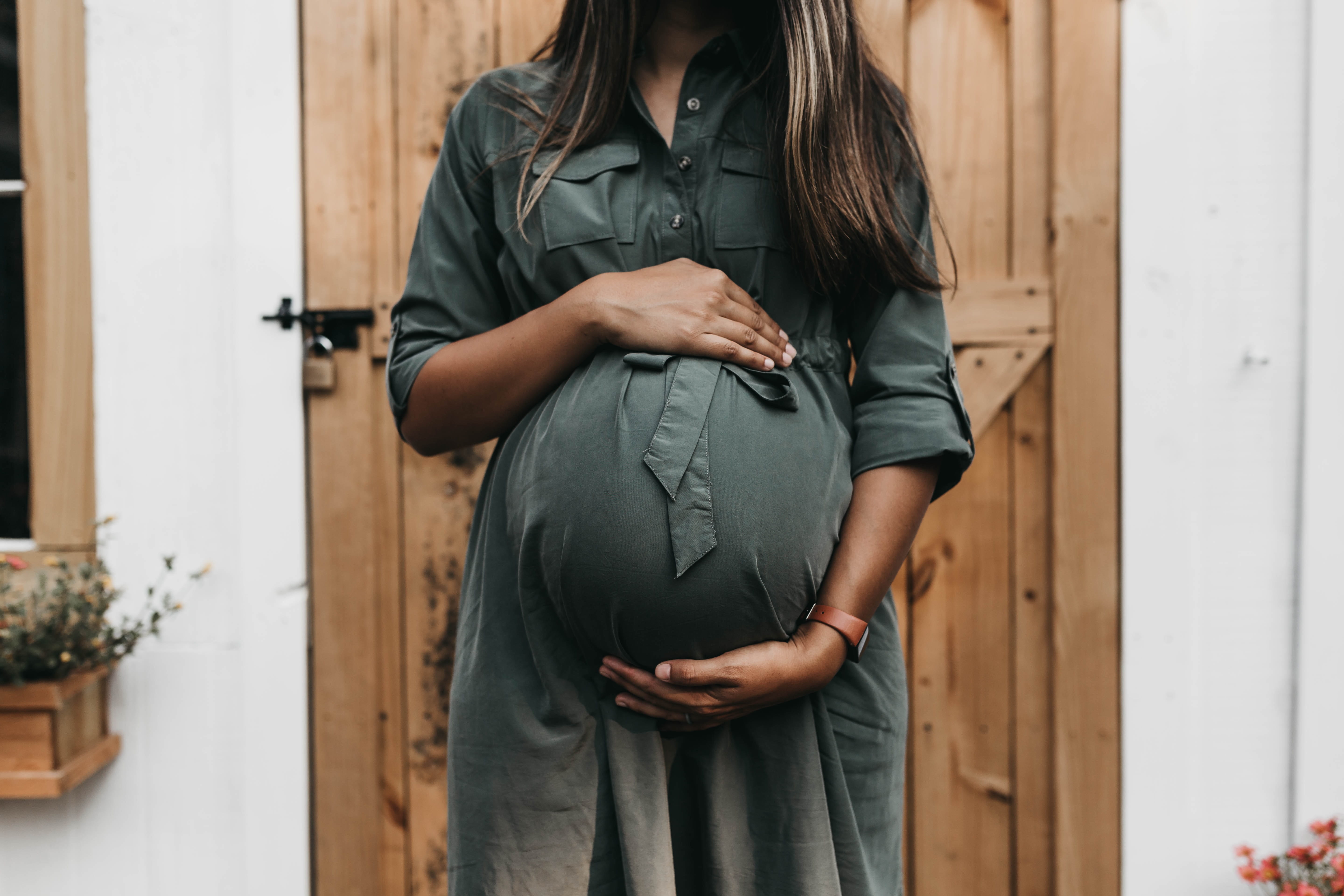 Photo of a pregnant woman with her hands on her stomach.