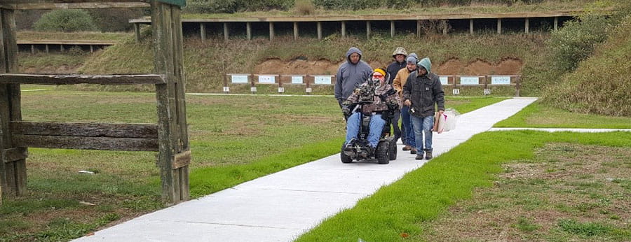 Man in wheelchair retrieving targets from accessible shooting range
