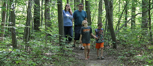 a family hiking on a trail in the woods
