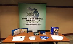 Table at outreach event with BTBL sign and promotional materials showing. Table at outreach event with BTBL sign and promotional materials showing.