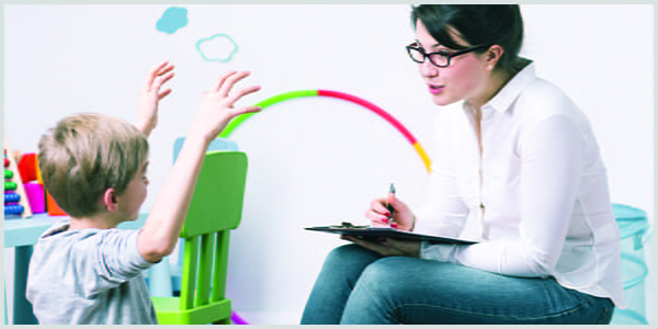 Boy excitedly telling story to enthusiastic counselor holding clipboard