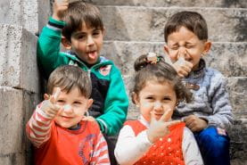 3 boys and 1 girl sitting on a stoop