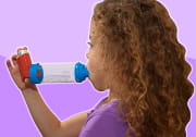 girl using asthma metered dose inhaler (MDI) with spacer