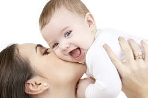 Mother kissing baby cheek