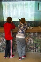 two boys try out the hunting simulator at the Outdoor Adventure Center two boys try out the hunting simulator at the Outdoor Adventure Center
