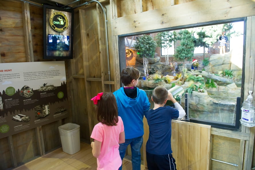 kids look through scope in Outdoor Adventure Center hunting blind, with view out of blind window kids look through scope in Outdoor Adventure Center hunting blind, with view out of blind window