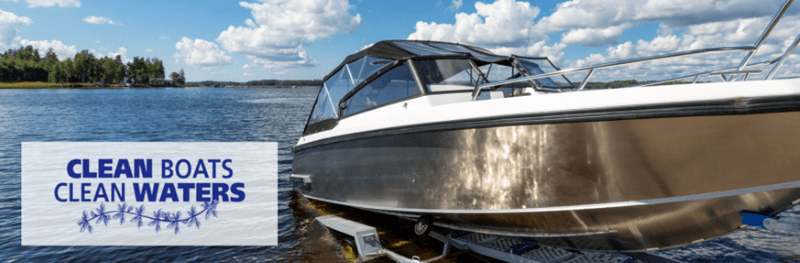 A boat being launched from a trailer into a lake. The Clean Boats, Clean Waters logo appears on the left.