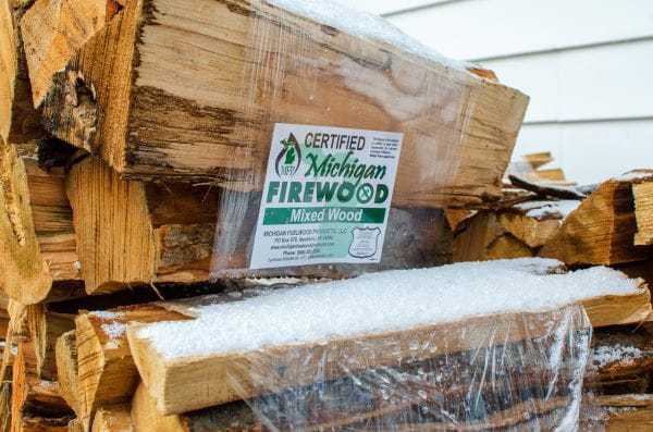 Bundles of certified heat treated firewood outside a convenience store.