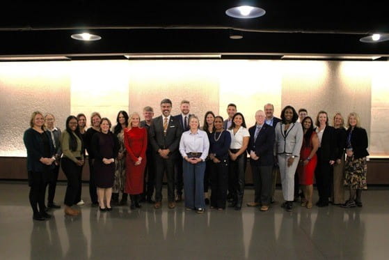 Several people dressed in professional wear posing for a photo