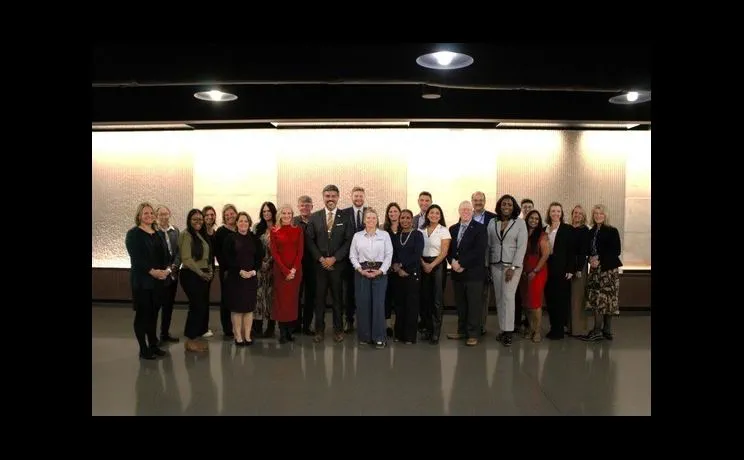 Several people dressed in professional wear posing for a photo