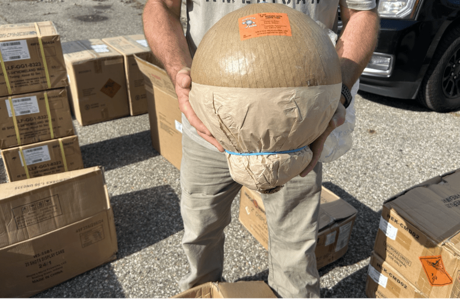 Photo of inspector holding a large circular firework