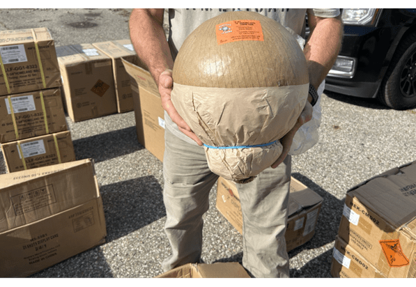 Photo of inspector holding a large circular firework