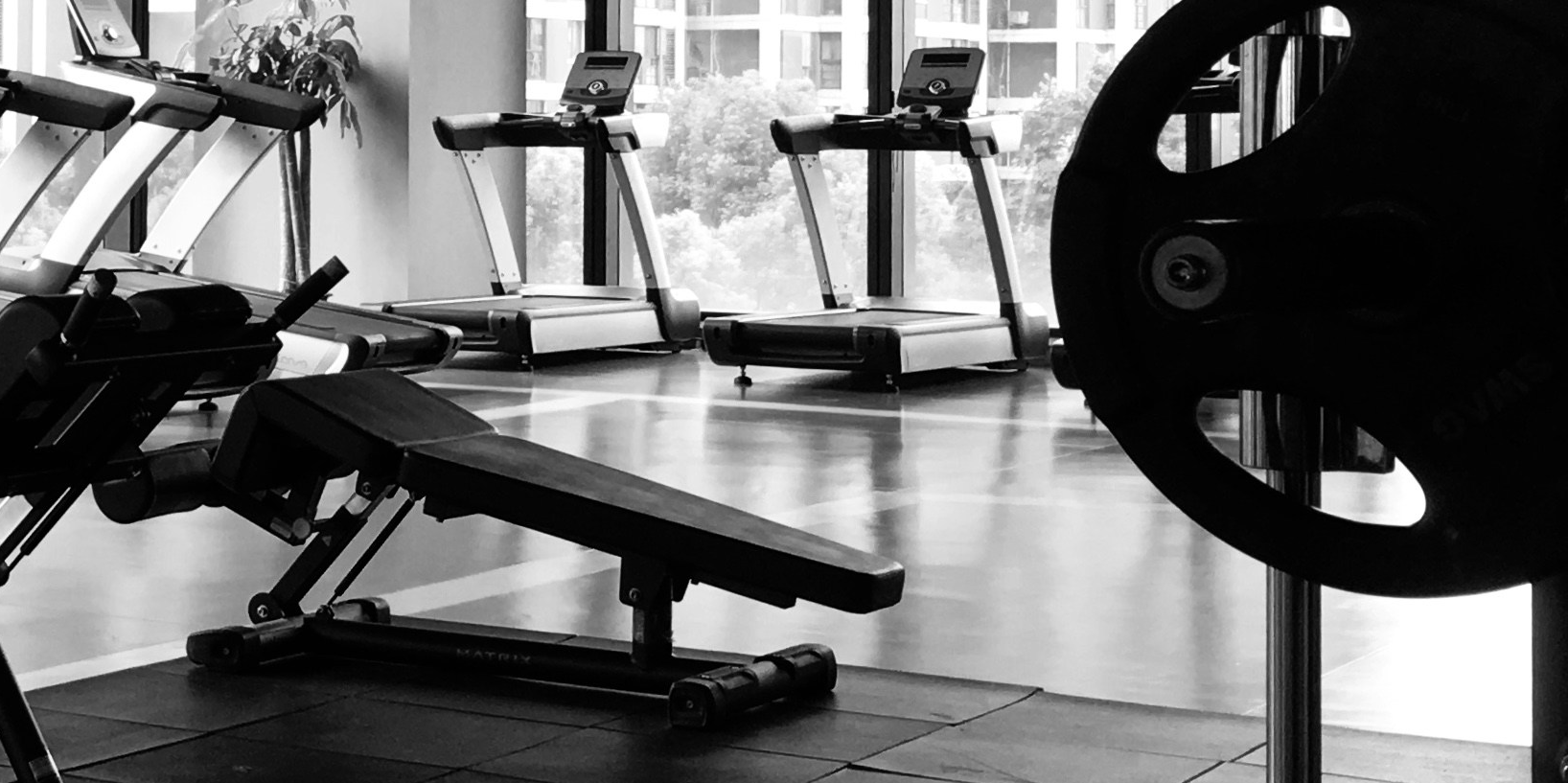 Black and white image looking into a gym with exercise equipment